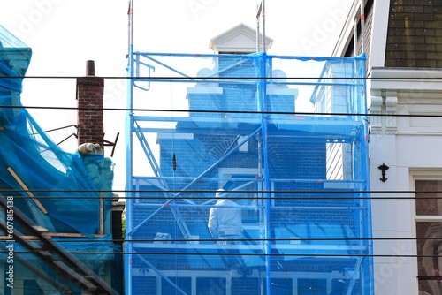 Historic House Facade Close Up with Blue Construction Screen and Scaffolding in Amsterdam, Netherlands photo