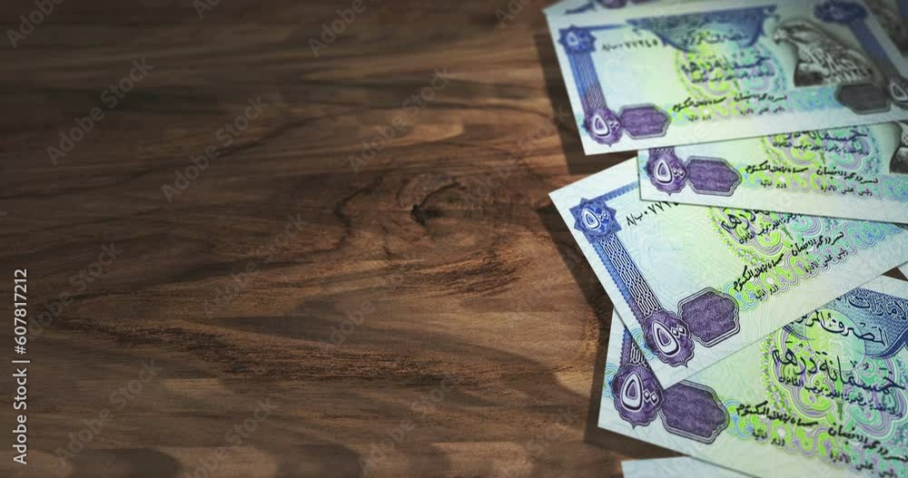 Emiratesian Dirham Dubai AED banknotes on the wooden table. Emirates currency paper notes 3D concept background. Seamless and looped. Emiratesian Dirham Dubai AED banknotes on the wooden table. Emirates currency paper notes 3D concept background. Seamless and looped.