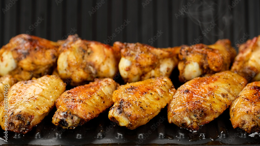 Fry chicken wings on grill, close up