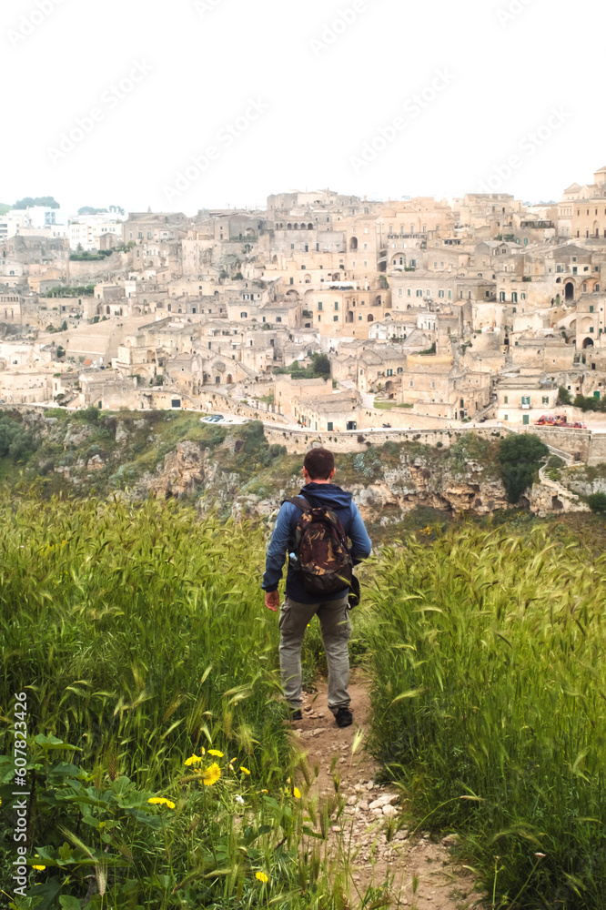 Active man hiking and tracking trail to old cave city Matera Italy in the meadow of Murgia Materana natural park in Basilicata Italy