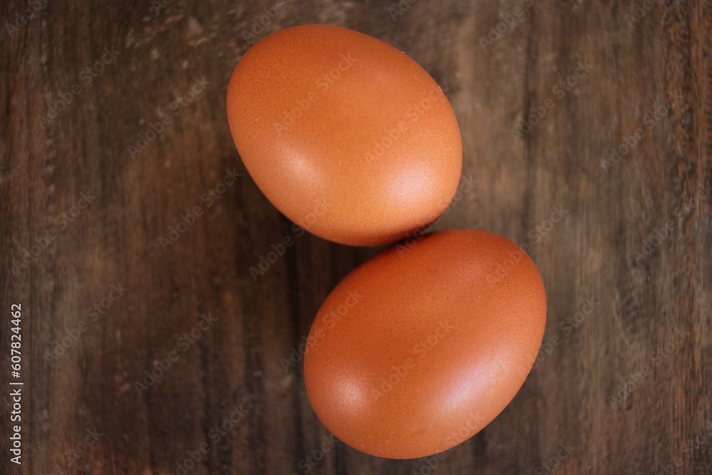 Close-up view of raw chicken eggs in egg basket on brown wooden background Close-up view of raw chicken eggs in egg basket on brown wooden background