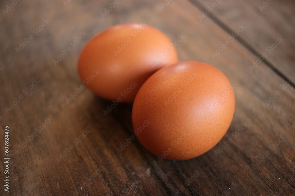 Close-up view of raw chicken eggs in egg basket on brown wooden background Close-up view of raw chicken eggs in egg basket on brown wooden background