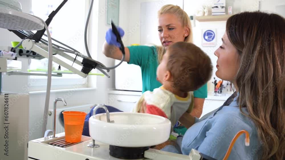 Little boy doing a teeth examination by a professional specialist in a pediatric dental office. The Boy is sitting in the mother lap.
Little boy doing a teeth examination by a professional specialist in a pediatric dental office. The Boy is sitting in the mother lap.