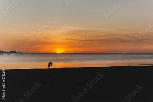 Silhouette of family looking sunset on the beach.