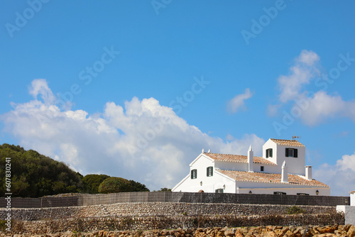 Country house on the island of Menorca (Balearic Islands, Spain). Typical white house of the Menorcan countryside surrounded by a dry stone wall. photo