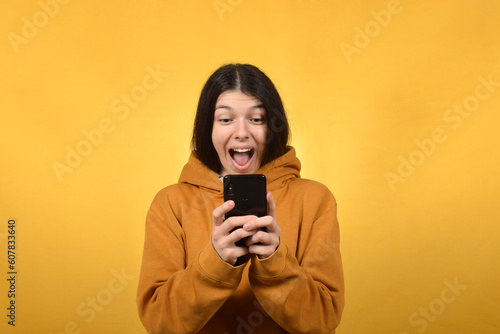 happy young brunette woman doing online shopping on smartphone