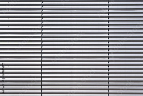 Wall made of strips of gray aluminum profile. Horisontal lines...