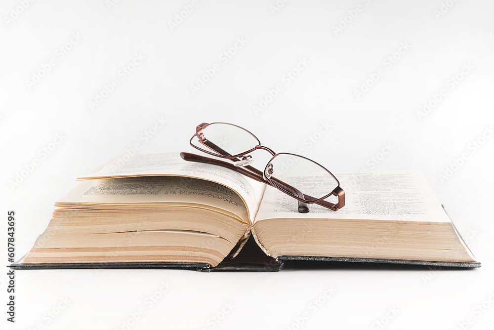 On a white background, an open bible and glasses. Religion concept.