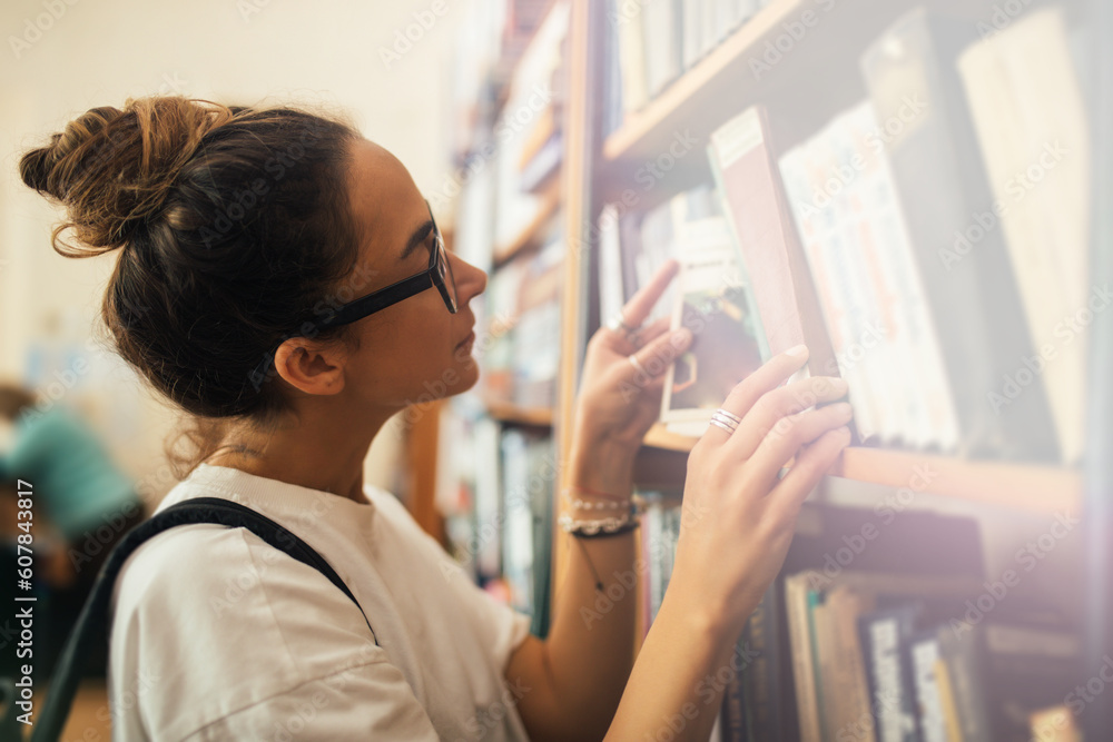A student stuying and reading books in a public library.