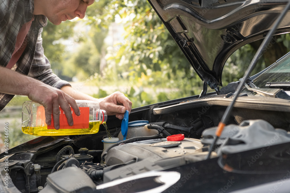 Fotka „Man pouring some windshield washer fluid in the special