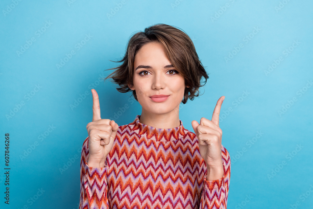 Photo portrait of pretty young girl point up fingers smile promo campaign wear trendy striped outfit isolated on blue color background Photo portrait of pretty young girl point up fingers smile promo campaign wear trendy striped outfit isolated on blue color background