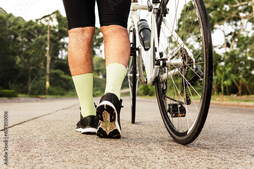 legs of cyclist walking on the road