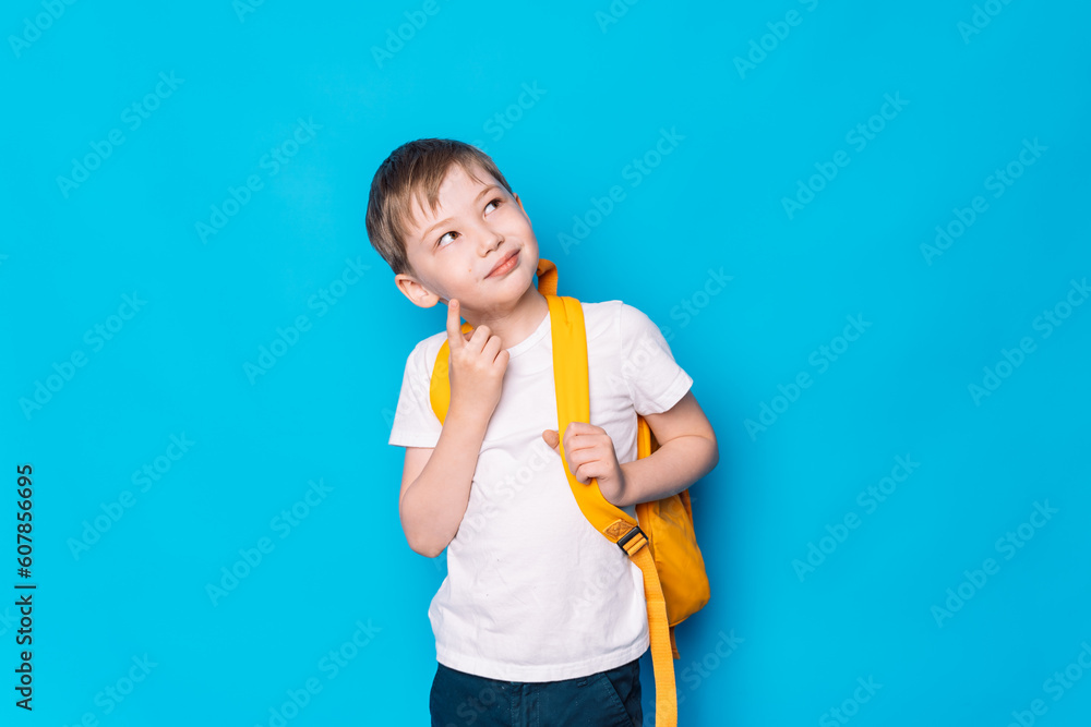 Schoolboy with a yellow backpack thought against a blue background. Schoolboy with a yellow backpack thought against a blue background.