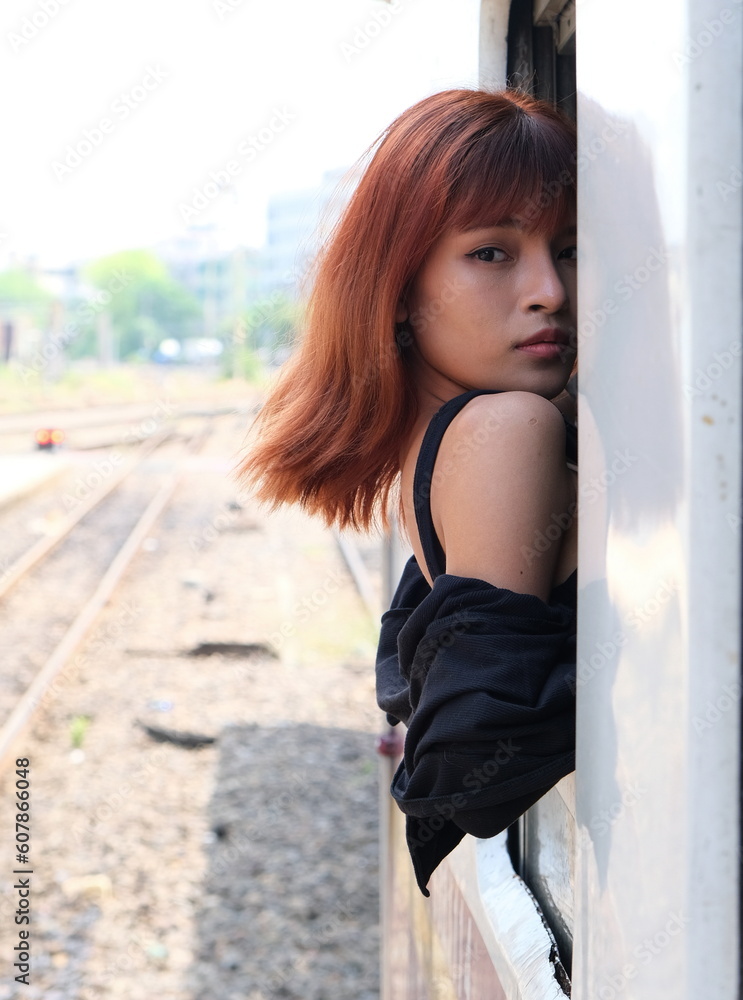Female traveler looks back through open window on a train Female traveler looks back through open window on a train