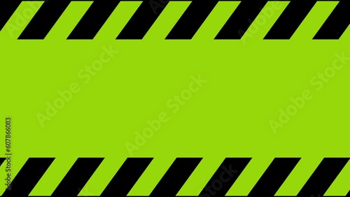 Rolling bright green warning tape, black stripes on a green background. Warning tape indicating increased danger, the stripes move from right to left. Looped video. photo
