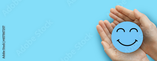 Hand holding paper cut circle symbol face smile, happy, relax,  satisfaction survey, customer services, positive, good, wellness, health child, hospital, world mental health day concept