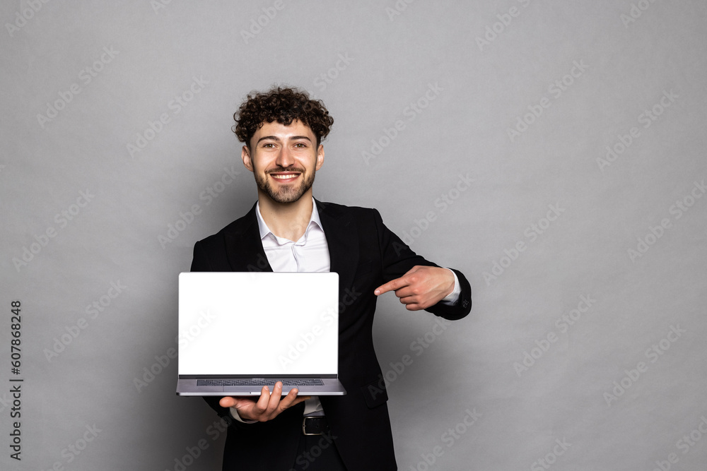 Optimistic man pointing finger at laptop with blank display, showing empty screen, bragging with internet advertisement Optimistic man pointing finger at laptop with blank display, showing empty screen, bragging with internet advertisement