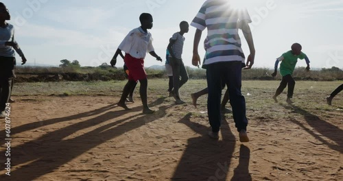 Poverty.  Slow motion. Poor Black African children playing soccer in a township slum.