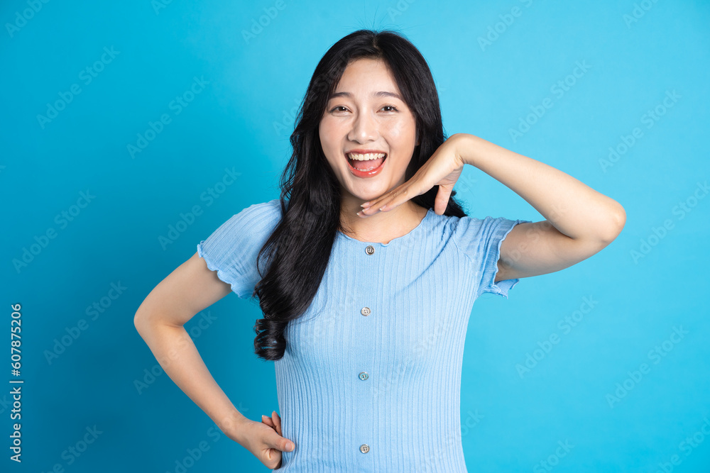 Portrait of a happy smiling asian girl posing on a blue background Portrait of a happy smiling asian girl posing on a blue background