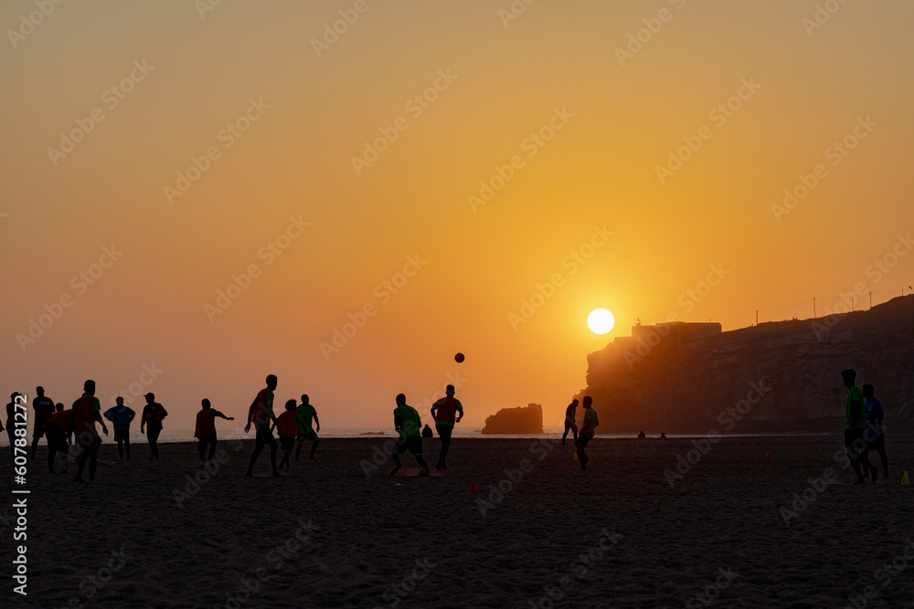 People playing soccer with a view o the sunset in Nazaré Beach
