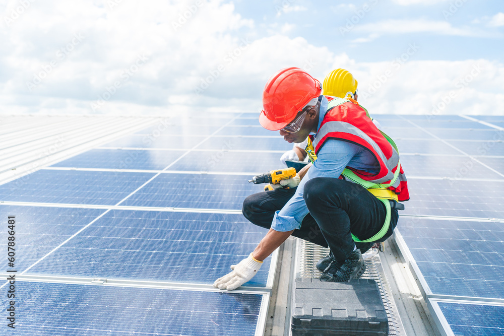 Professional worker cleaning solar panels with brush and washing with water on roof structure of building factory. Technician using mop to clean the dirty and dust, green electricity energy technology Professional worker cleaning solar panels with brush and washing with water on roof structure of building factory. Technician using mop to clean the dirty and dust, green electricity energy technology