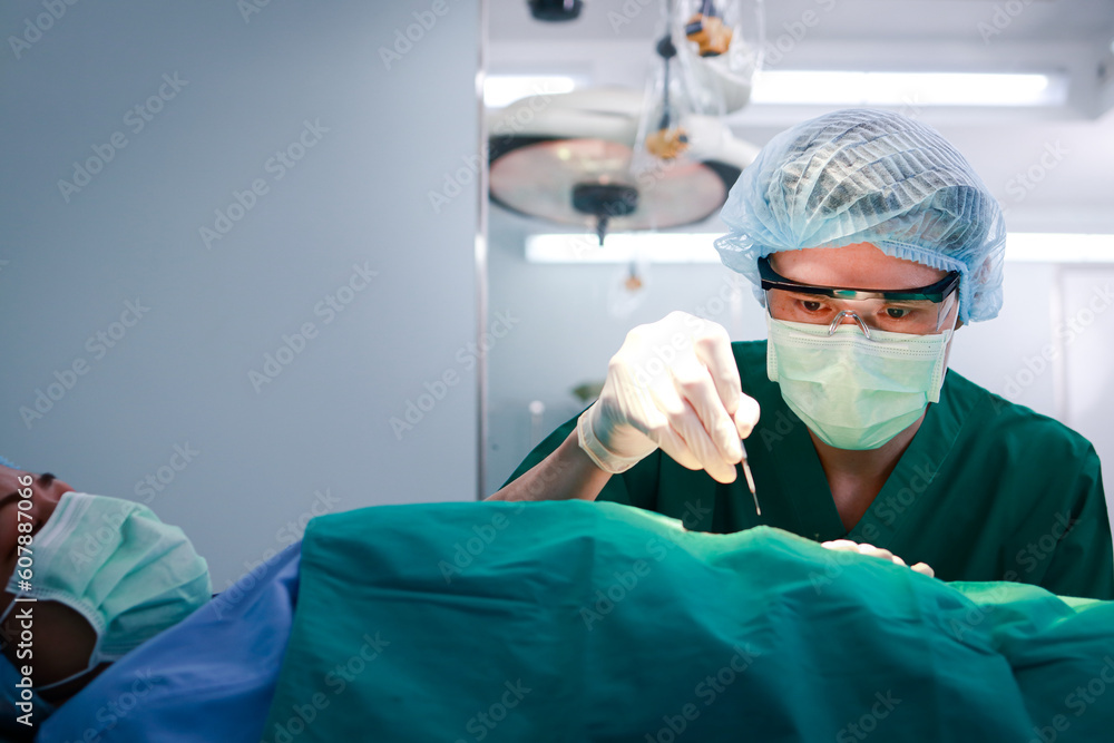 A surgeon or doctor in green uniform holding a scalpel performs an operation in a hospital. Emergency surgery. abdominal surgery A surgeon or doctor in green uniform holding a scalpel performs an operation in a hospital. Emergency surgery. abdominal surgery
