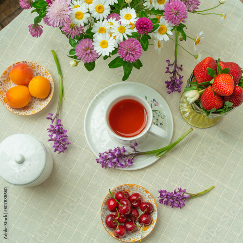 Morning tea with flowers and fruits on the terrace of a country house.