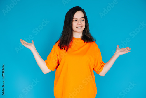 Smiling Young Woman Holding Empty Copy Space in Palms, Attractive Female Model, Isolated on Bright Blue Background, Portrait Photo