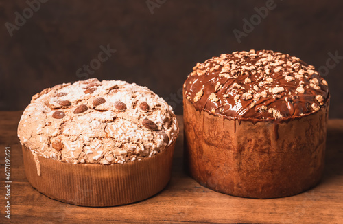 Panettone Italian Christmas sweet bread dark background copy space. Different type of Panettone with chocolate topping and glazed covered topping with almonds. photo