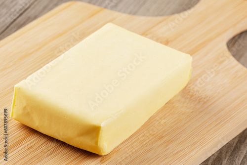 Block of Organtic butter islated on a wooden chopping board