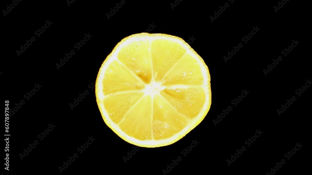 A sliced lemon rotates on a black background. Citrus fresh lemon fruit. A sliced lemon rotates on a black background. Citrus fresh lemon fruit.