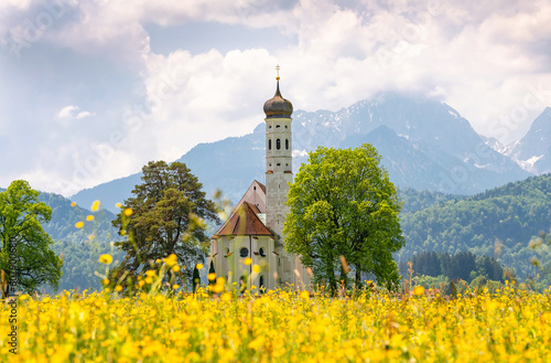Catholic church in Bavaria St. Coloman. View against the backdrop of the Alpine mountains photo