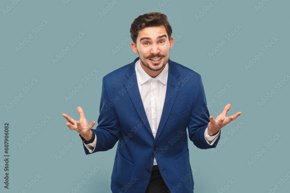Portrait of aggressive attractive man with mustache standing with clenched hands, yelling with hate and anger, wearing official style suit. Indoor studio shot isolated on light blue background. Portrait of aggressive attractive man with mustache standing with clenched hands, yelling with hate and anger, wearing official style suit. Indoor studio shot isolated on light blue background.