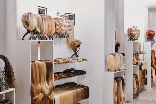 Fotografie, Obraz Showcase of natural looking wigs in different colors fixed on the metal wig holders in beauty salon
