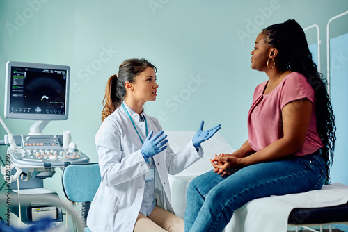 Female doctor talking to black woman during medical examination at the clinic.