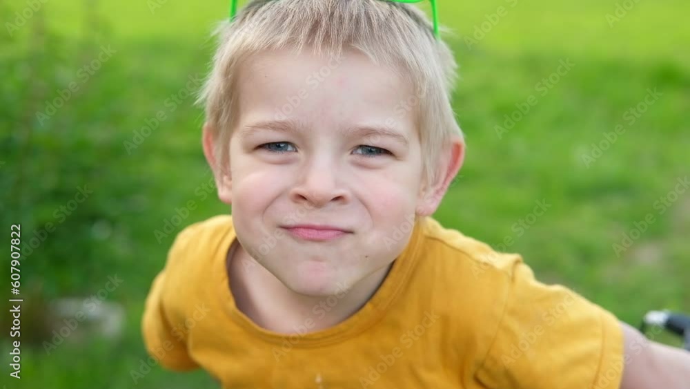 Boy joking, sticking tongue out with silly expression. Child making face. Funny foolishness portrait of little toddler outdoors. Nature background. Adorable caucasian kid making crazy comical gesture Boy joking, sticking tongue out with silly expression. Child making face. Funny foolishness portrait of little toddler outdoors. Nature background. Adorable caucasian kid making crazy comical gesture