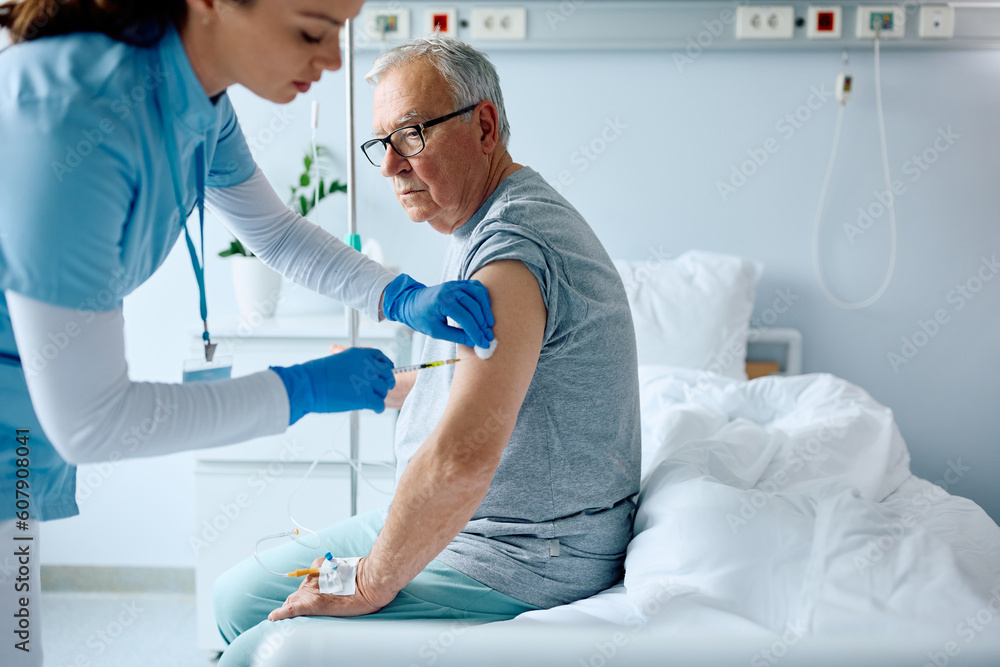Senior man receiving vaccine while recovering in hospital. Senior man receiving vaccine while recovering in hospital.