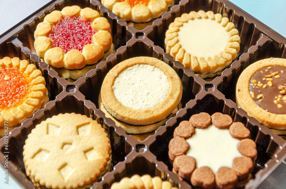 Close-up of various cookies in box. Butter biscuits round in assortment with jam, chocolate, fondant Close-up of various cookies in box. Butter biscuits round in assortment with jam, chocolate, fondant