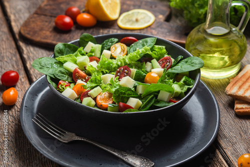 Salad of spinach, cherry tomatoes and cheese in a plate
