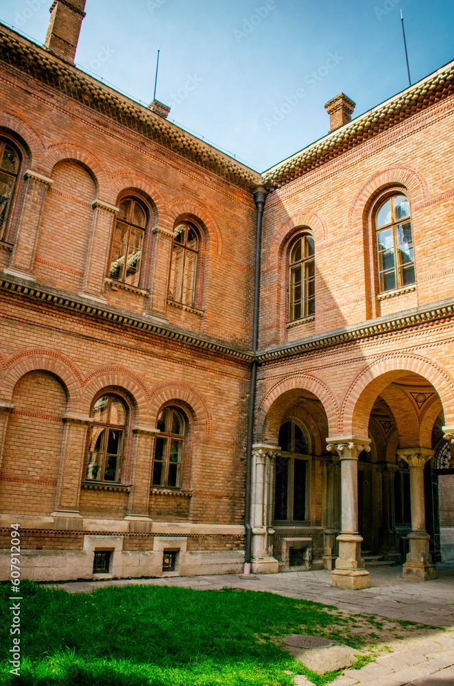 The facade of an old building with arched red brick windows. High quality photo