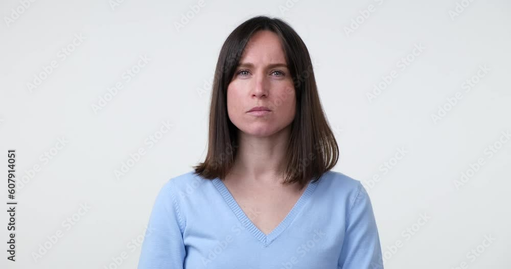 A Caucasian woman stands on a white background, making the hush gesture by placing a finger on her lips. Her face expresses seriousness and the need for secrecy. A Caucasian woman stands on a white background, making the hush gesture by placing a finger on her lips. Her face expresses seriousness and the need for secrecy.