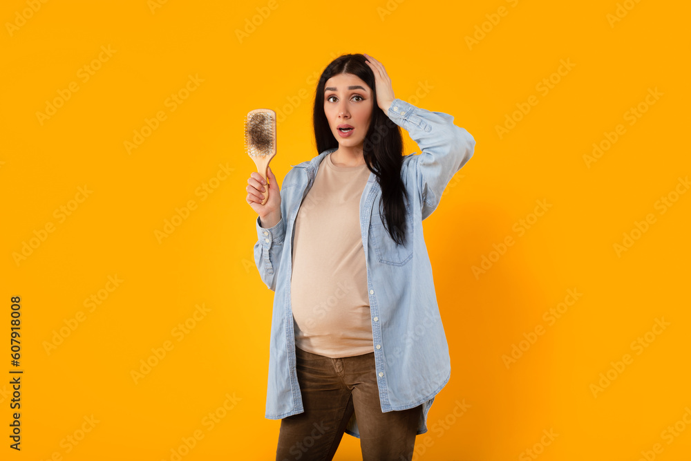 Pregnancy changes. Young expectant mother grappling with hair loss, having problems causes by hormone balances Pregnancy changes. Young expectant mother grappling with hair loss, having problems causes by hormone balances