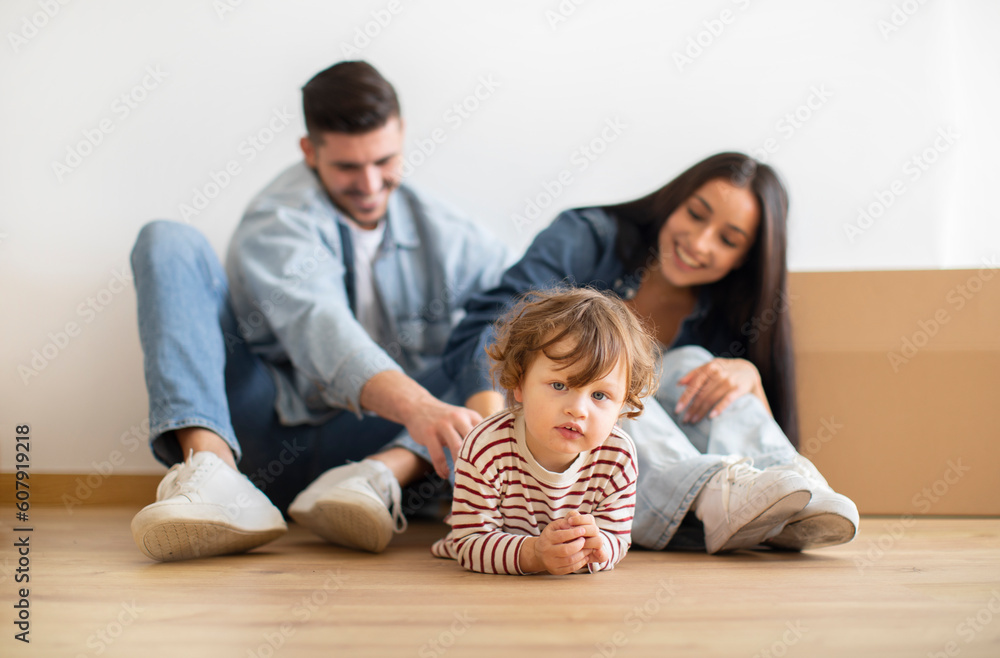 Happy Family Of Three With Little Kid Posing Together On Moving Day Happy Family Of Three With Little Kid Posing Together On Moving Day