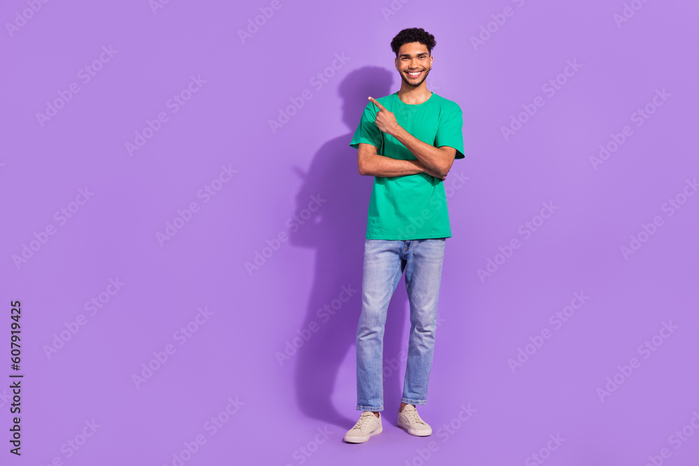 Full length portrait of positive nice man direct finger empty space news isolated on purple color background Full length portrait of positive nice man direct finger empty space news isolated on purple color background