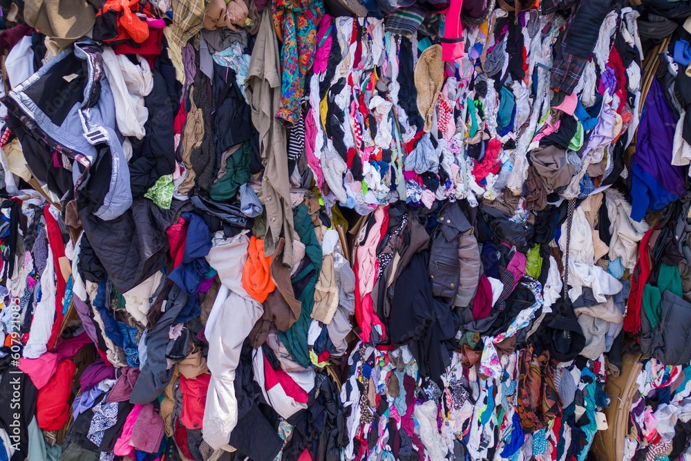 A wall of clothes with a lot of clothes on it. second hand.  clothes background. clothes recycling 
