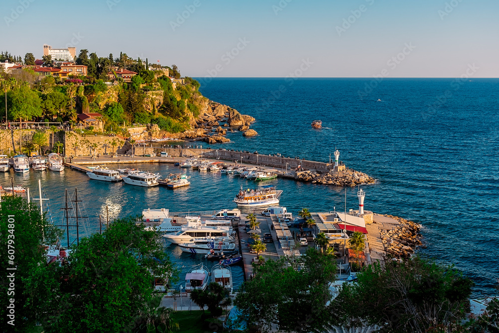 View from a height of the harbor near the old town of Kaleichi in the Turkish city of Antalya. Old port in Antalya with many ships and boats. Popular tourist place in Anatalya. - obrazy, fototapety, plakaty 