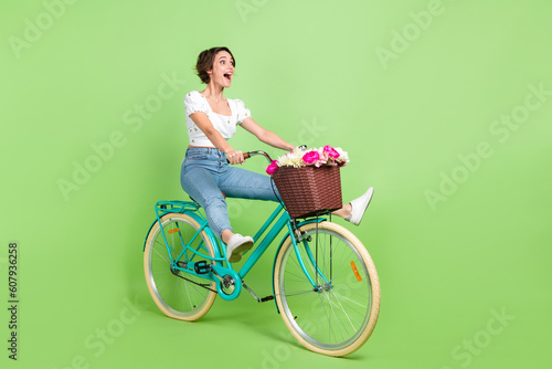 Fototapeta Naklejka Na Ścianę i Meble -  Full length photo of cute adorable woman dressed white blouse speed riding cycle transport isolated green color background