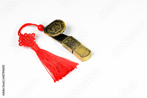 Traditional chinese brass amulet as presents. Chinese style amulet with red decorative good luck knots means good fortune, happiness and rich on white background.