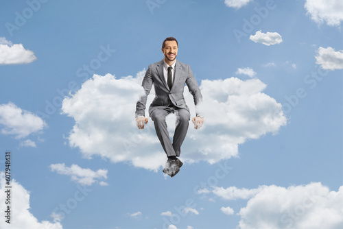 Wallpaper Mural Businessman in a grey suit sitting on a cloud and smiling Torontodigital.ca