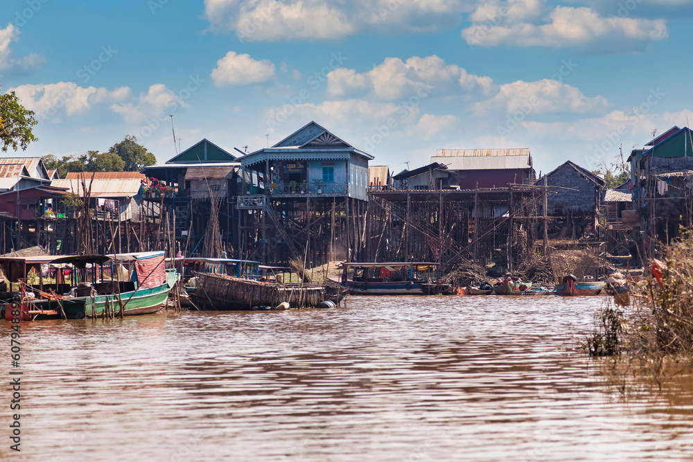 Tonle Sap lake, boats and houses on stilts on rural river, Kompong Phluk floating fishing village in drought season. Life and work cambodian people, residents poverty country Cambodia. Copy text space
